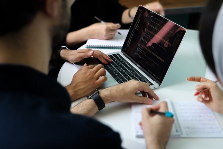 Business team collaborating around a laptop